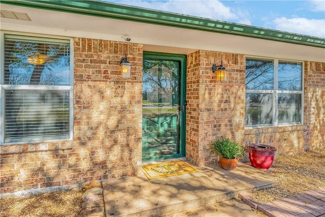 doorway to property featuring brick siding