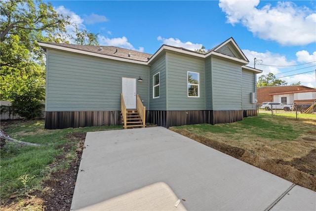 rear view of house featuring a patio area and a yard