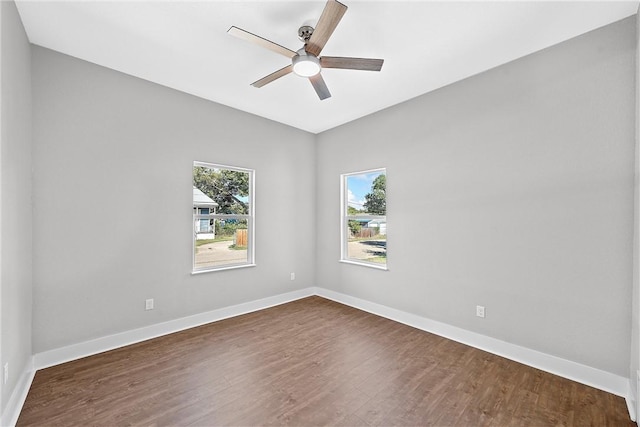 empty room with dark hardwood / wood-style floors and ceiling fan