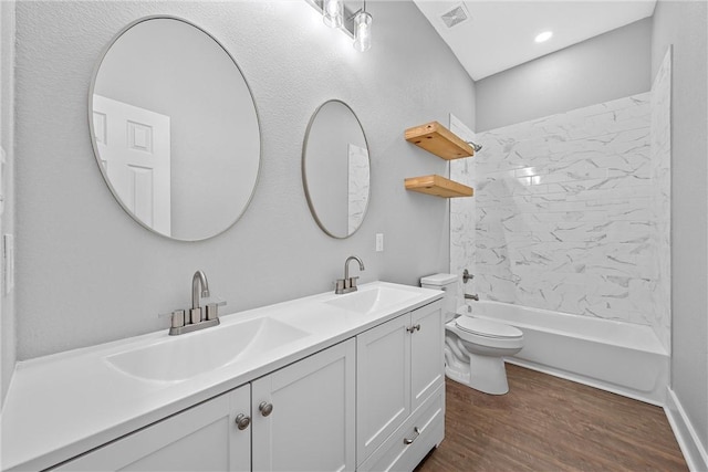 full bathroom with vanity, toilet, tiled shower / bath, and wood-type flooring