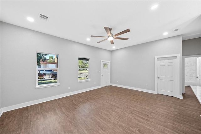 empty room with ceiling fan and dark hardwood / wood-style flooring