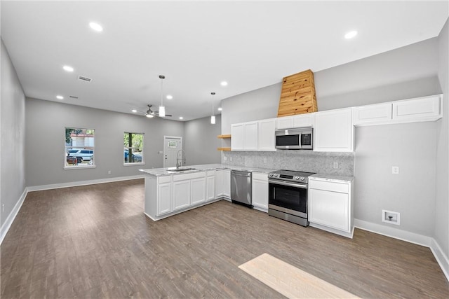 kitchen with sink, stainless steel appliances, white cabinetry, and kitchen peninsula