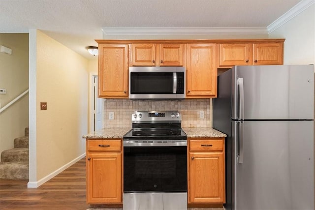 kitchen featuring tasteful backsplash, light stone counters, dark hardwood / wood-style flooring, and stainless steel appliances