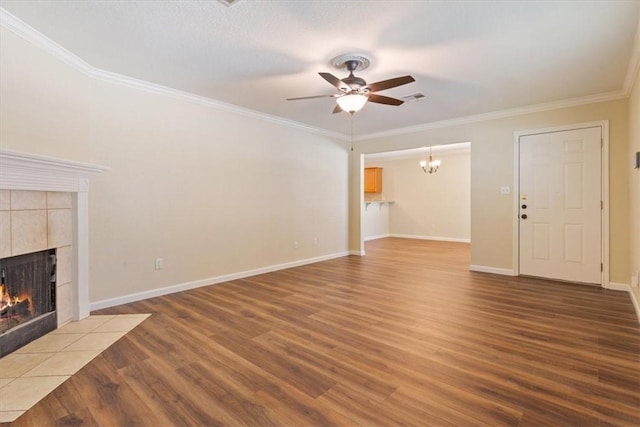 unfurnished living room featuring hardwood / wood-style floors, ceiling fan, crown molding, and a fireplace