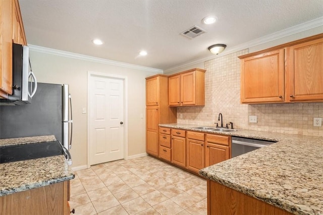 kitchen with appliances with stainless steel finishes, light stone counters, crown molding, and sink