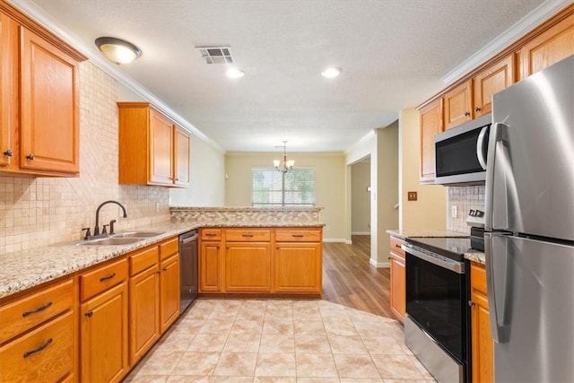 kitchen featuring kitchen peninsula, ornamental molding, stainless steel appliances, a notable chandelier, and hanging light fixtures