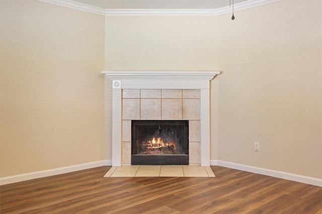 interior details with a tile fireplace, crown molding, and wood-type flooring