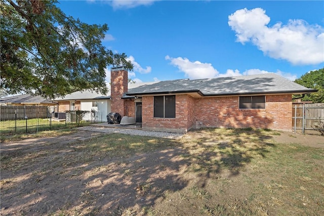 back of house with a lawn and a patio