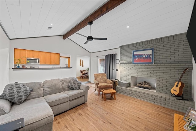 living room with vaulted ceiling with beams, ceiling fan, light hardwood / wood-style floors, and a fireplace