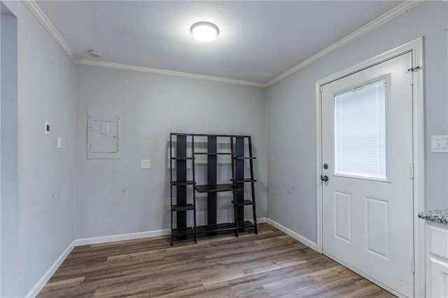 interior space featuring hardwood / wood-style flooring, ornamental molding, and electric panel