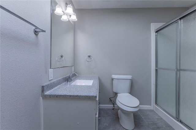 bathroom featuring vanity, an enclosed shower, tile patterned flooring, and toilet