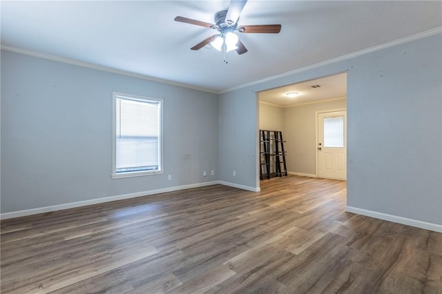 empty room with wood-type flooring, a wealth of natural light, and crown molding