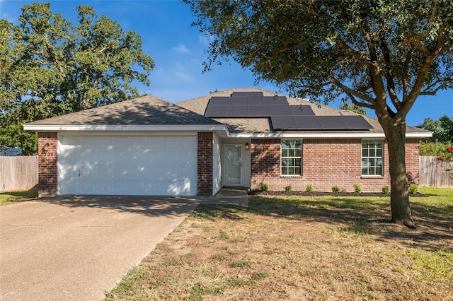 ranch-style house featuring solar panels, a garage, and a front lawn