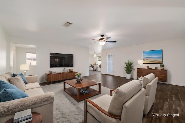 living room featuring dark hardwood / wood-style floors and ceiling fan