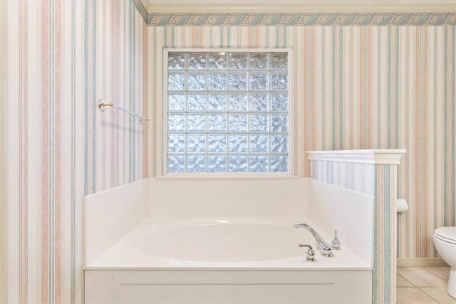 bathroom featuring a bath, tile patterned floors, and toilet