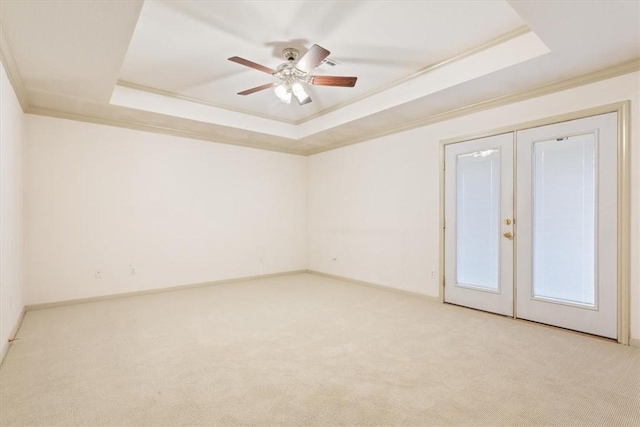 carpeted spare room with ornamental molding and a tray ceiling