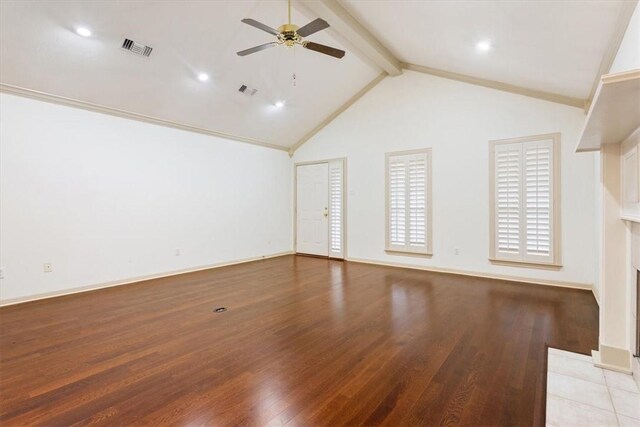 unfurnished living room with crown molding, dark wood-type flooring, built in features, a tile fireplace, and vaulted ceiling