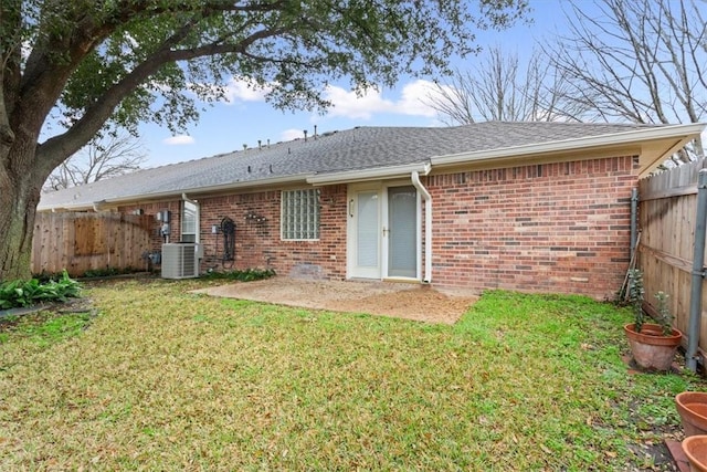 back of property with a yard and central AC unit