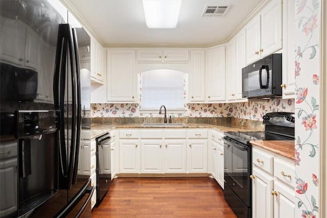 kitchen with white cabinetry, sink, black appliances, and light wood-type flooring