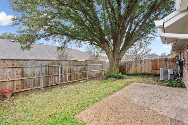 view of yard with central AC and a patio