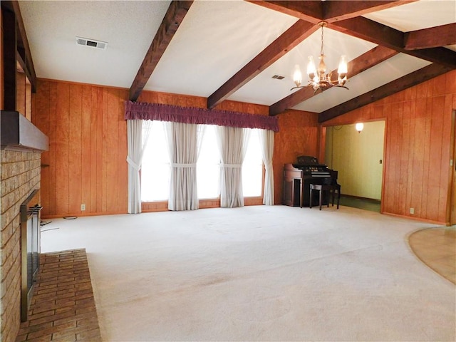 unfurnished living room featuring a brick fireplace, visible vents, wooden walls, and carpet flooring