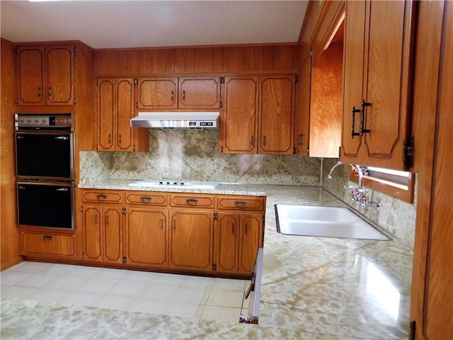 kitchen featuring white electric stovetop, double wall oven, light countertops, a sink, and under cabinet range hood