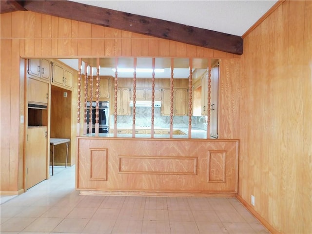 interior space featuring vaulted ceiling with beams, light floors, and wood walls