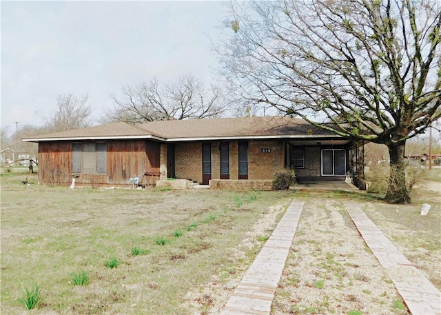 view of front of home with a front yard and brick siding