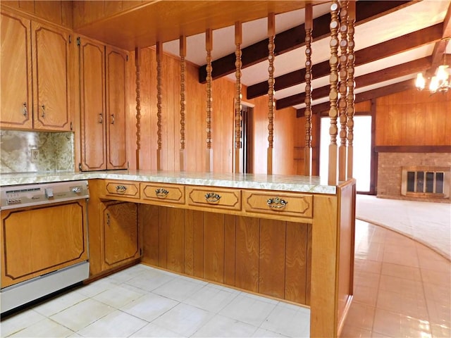 kitchen featuring light countertops, brown cabinetry, a brick fireplace, and paneled dishwasher