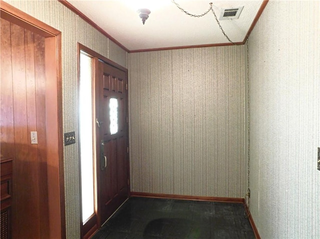 entryway with ornamental molding, visible vents, baseboards, and wallpapered walls