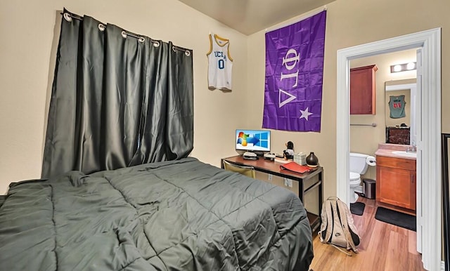 bedroom featuring connected bathroom and light wood-type flooring