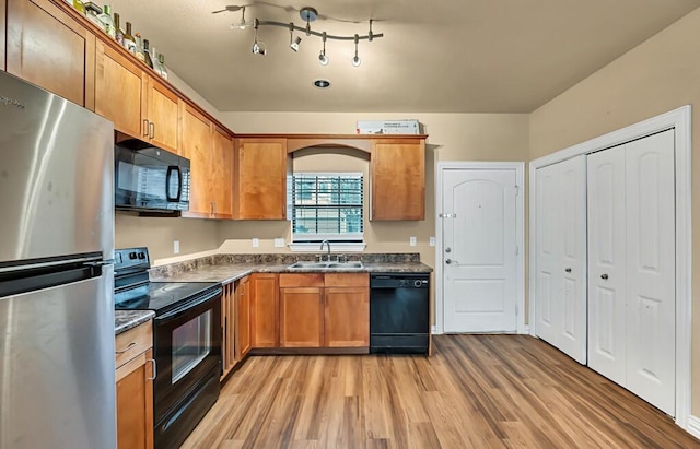 kitchen with light wood-type flooring, sink, and black appliances