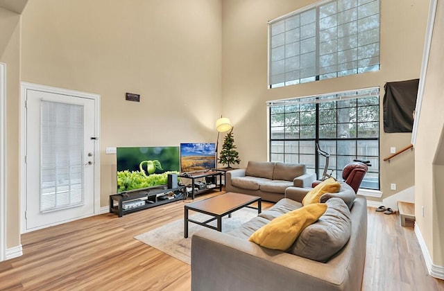 living room featuring hardwood / wood-style floors and a towering ceiling