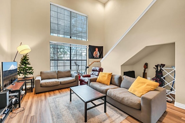 living room with hardwood / wood-style floors and a towering ceiling