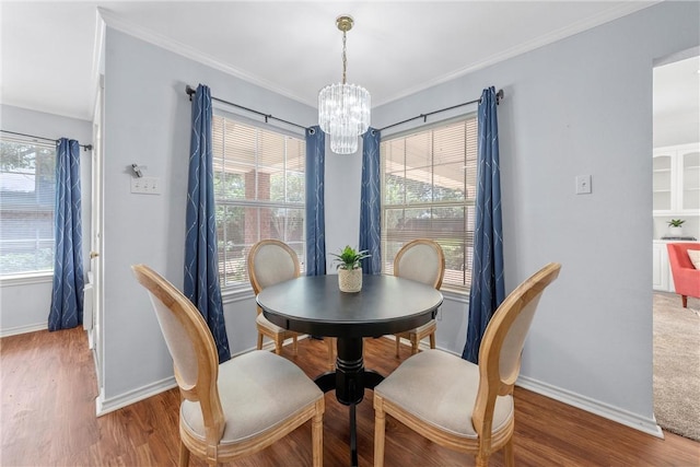 dining space with hardwood / wood-style floors, ornamental molding, and a healthy amount of sunlight