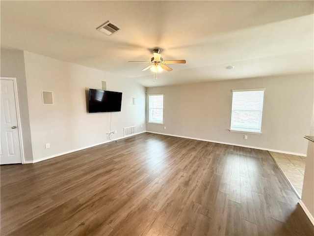 unfurnished living room featuring dark wood-type flooring and ceiling fan