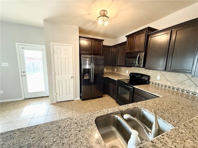 kitchen with light stone counters, sink, and stainless steel appliances