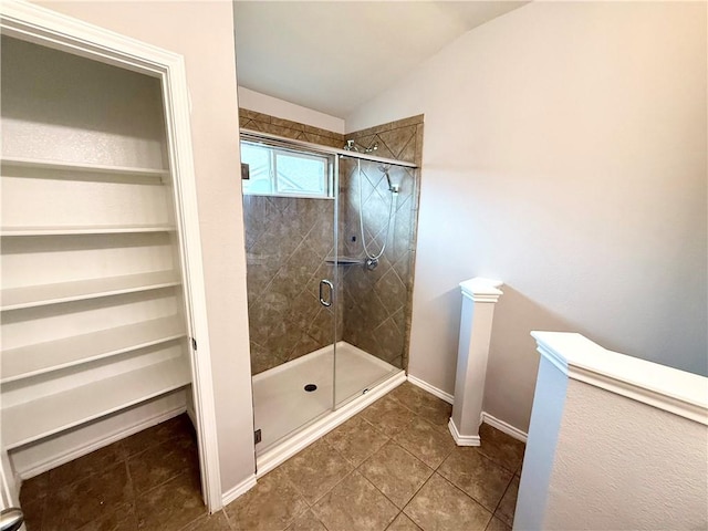 bathroom featuring walk in shower, tile patterned floors, and vaulted ceiling