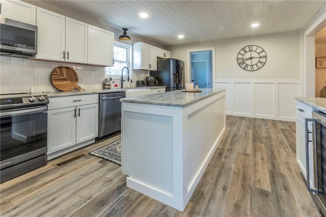 kitchen featuring stainless steel appliances, a center island, white cabinets, and wood ceiling