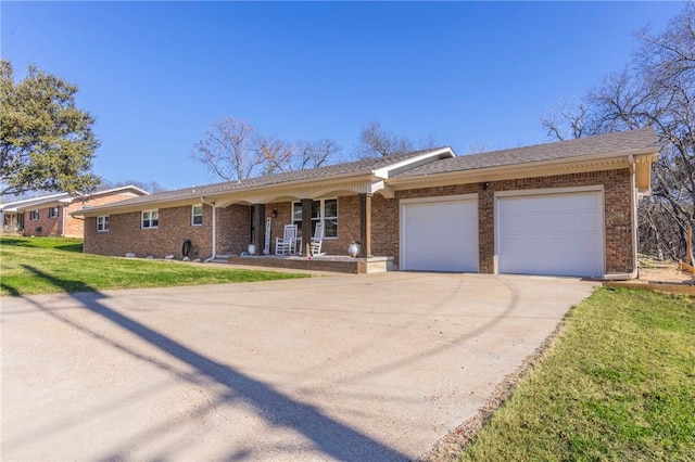 ranch-style house featuring concrete driveway, an attached garage, covered porch, a front lawn, and brick siding