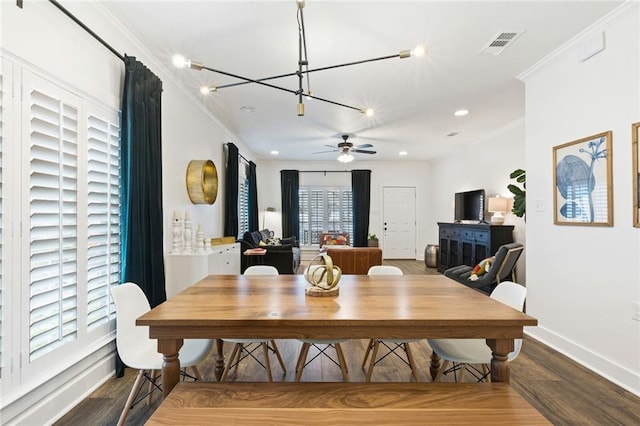 dining area with wood-type flooring, ceiling fan with notable chandelier, and ornamental molding