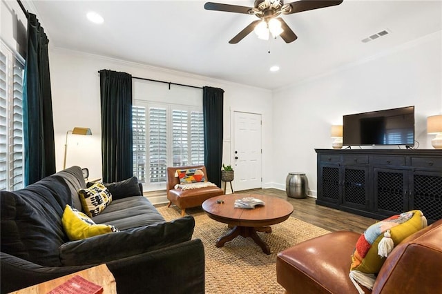 living room with hardwood / wood-style floors, ceiling fan, and crown molding