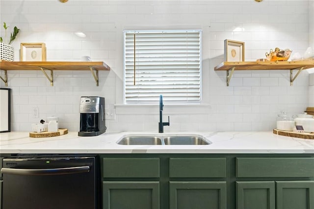 kitchen featuring stainless steel dishwasher, green cabinets, light stone countertops, and sink