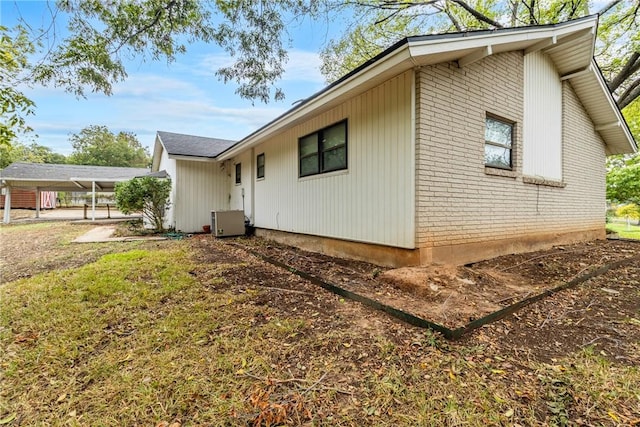 view of side of home featuring central AC unit and a carport