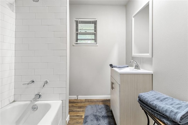 bathroom with vanity, hardwood / wood-style floors, and tiled shower / bath combo