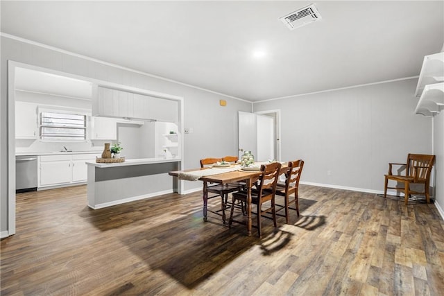 dining area with crown molding, dark hardwood / wood-style flooring, and wooden walls