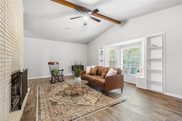 living room featuring hardwood / wood-style floors, vaulted ceiling with beams, a brick fireplace, and ceiling fan