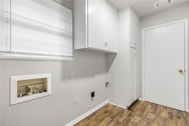 laundry room featuring electric dryer hookup, hookup for a washing machine, dark hardwood / wood-style flooring, and cabinets