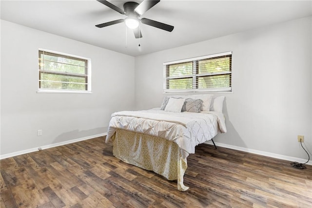 bedroom with multiple windows, ceiling fan, and dark wood-type flooring