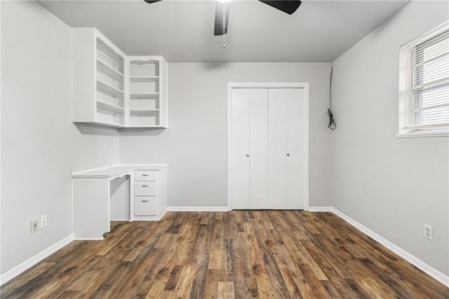 unfurnished office with ceiling fan and dark hardwood / wood-style floors